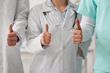 Group of doctors showing thumb-up in clinic