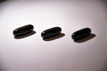 small black pills, capsules on a white background