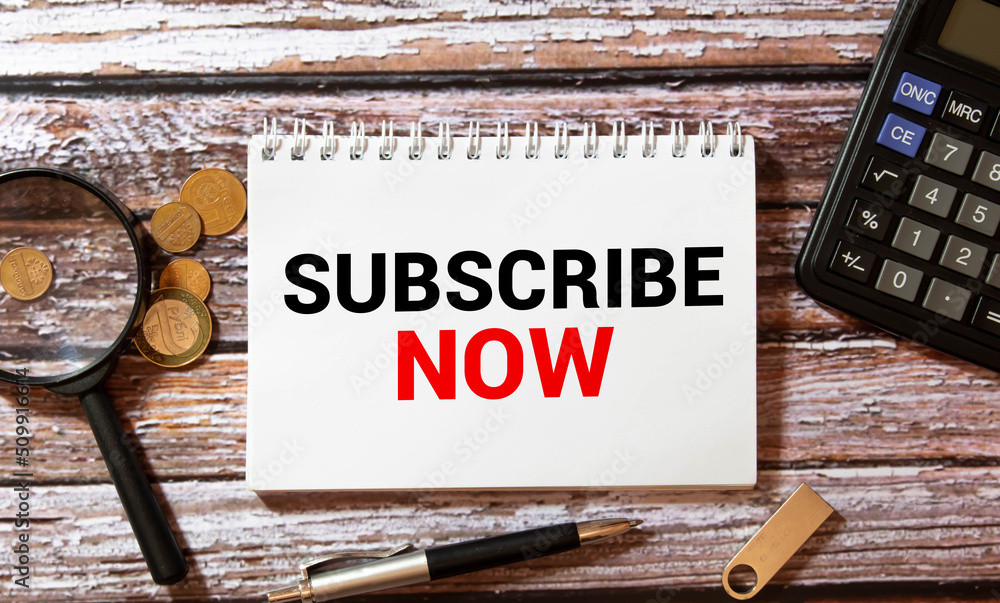 Poster on a white notepad, a red pen, a red notepad and a white sheet of paper with the text subscribe now.