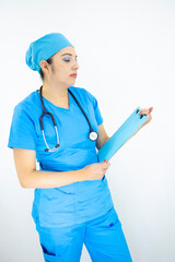 beautiful woman medical, wearing uniform and blue surgical cap, stethoscope on her neck, holding clipboard with results, on white background
