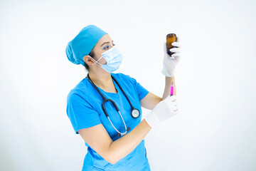 Beautiful woman doctor wearing mask face, uniform and blue surgical cap, stethoscope and latex gloves, preparing injection on white background