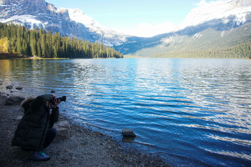 호수가에 앉아서 사진을 찍고 있는 남자, A man sitting on the lake and taking pictures
