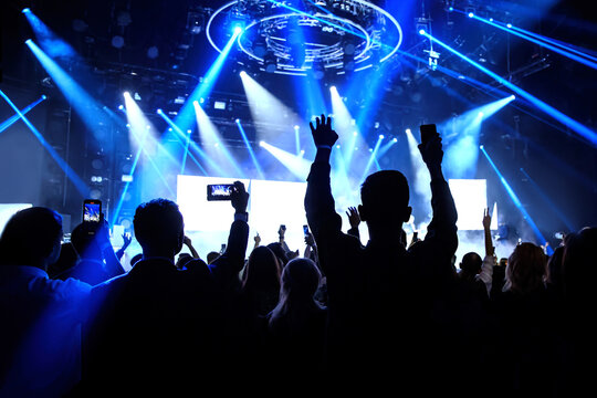 Happy crowd with raised hands at a rock concert.