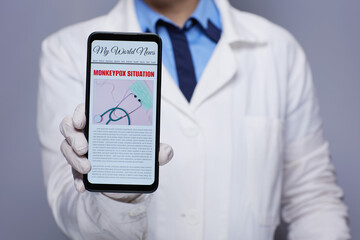 Medical doctor woman showing smartphone with monkeypox news