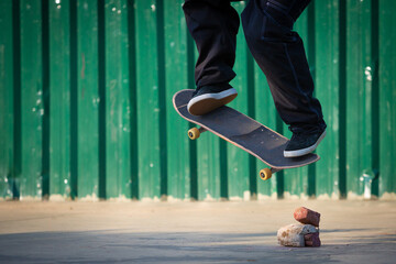 Skateboarder jumping obstacles made of bricks and stones