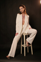 Portrait of a beautiful fashion woman brunette in a white business suit in the studio