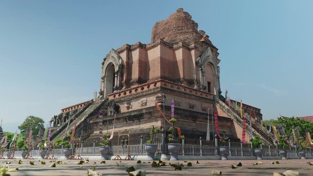 4K Cinematic landscape footage of the buddhist temple monument of Wat Chedi Luang in the old town of Chiang Mai, Thailand on a sunny day.