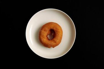 Donuts with high calories and plenty of sugar in the plate on the table