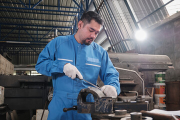 One professional Asian male industry engineer worker works in a safety uniform with metalwork...