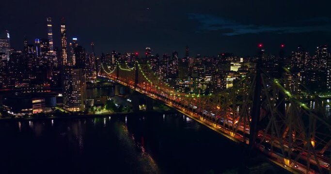 Wonderful Queensboro Bridge lit in green and orange. New York scenery full of lights at night time. Top view.