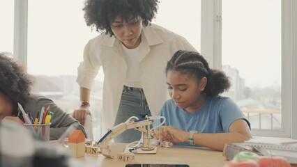 Classroom with diverse learners of happily African American students and teacher doing activities together. The teacher is teaching, guiding and talking to the children in diverse.