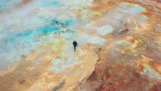 Man Walks On Mars Formations in The Hverir Geothermal Area Near Lake Myvatn.