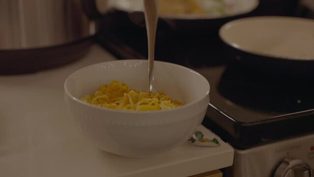 Male mixes spaghetti squash recipe on modern kitchen counter.