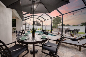 Outdoor table on pool patio at dusk with pretty sky