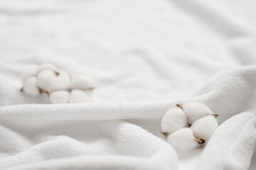 Cotton flowers on a white terry towel with copy space.