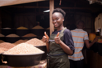 A beautiful and happy African Nigerian female trader, seller, business woman or shop owner...