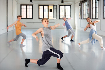 Emotional teenage dancers having hip-hop dance training at dance hall