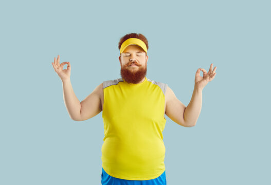 Funny man with beard in yoga position on studio pink background