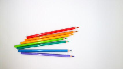 colored pencils in row on a white background top view.