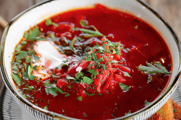 Bowl of russian beet soup borscht on wooden background
