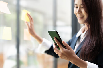 Fototapeta premium Closeup image of a businesswoman using mobile phone in office