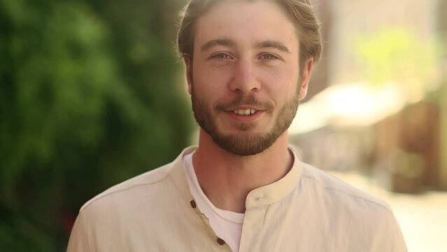 Caucasian attractive bearded correspondent talking while being on air in news from center city street. 