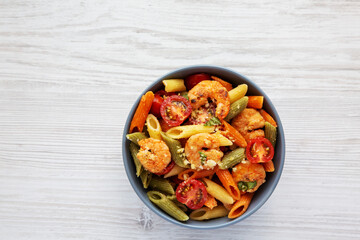 Homemade Tri-Color Penne Salad with Shrimp, Tomato and Basil Bread Crumbs in a Bowl, top view. Flat lay, overhead, from above.