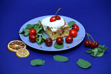 Delicious cake with white fondant and red cherry. on the plate. bay leaf, dried lemon wedge. Confectionery, cakes. food. sweet concept.	