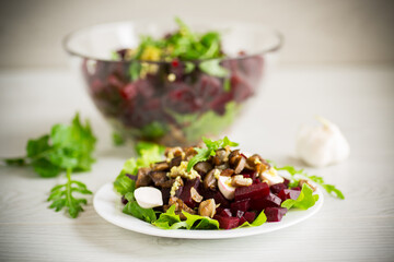 Salad with boiled beets, fried eggplants, herbs and arugula in a plate
