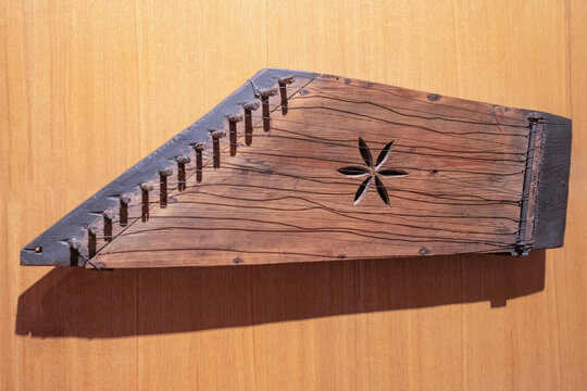 Wooden Gusli on wood background. Ancient East Slavic stringed plucked musical instrument. Top view, close-up.