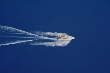 Speed boat movement at high speed aerial view. High-speed yacht of white color fast motion on blue...