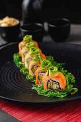 Sushi set of various products on a black stone plate. Blur background and selective focus