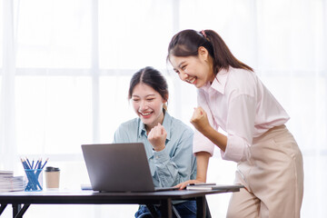 Checking the numbers. Team of Asian young business people analyzing data using a computer while talking about marketing strategy and planning working in the office