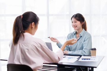 Fototapeta premium Checking the numbers. Team of Asian young business people analyzing data using a computer while talking about marketing strategy and planning working in the office