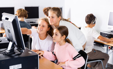 Portrait of female and male students working on computers in classroom