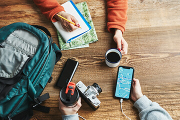 Family planning vacation trip. Girl searching travel destination and routes using navigation map on mobile phone. Charging smartphone with power bank. Using technology while travelling © Przemek Klos