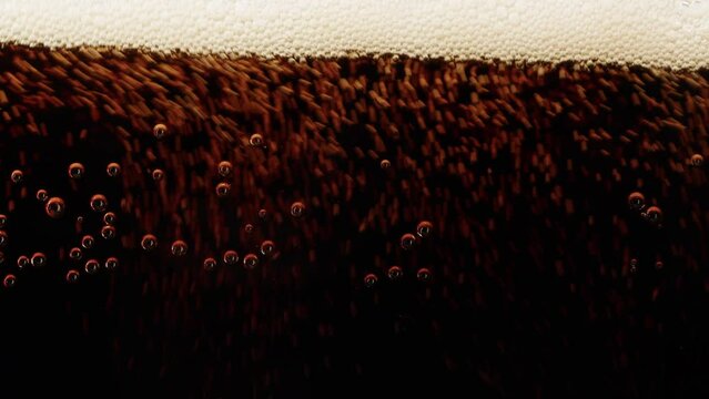 Cold lemonade in glass close-up. Coca cola with ice macro shooting texture. Refreshing cocktail on blue background. 