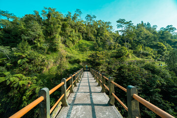 Iconic bridge in one of the tourist destinations in Kali Kuning, Sleman, Indonesia with green hills in the morning