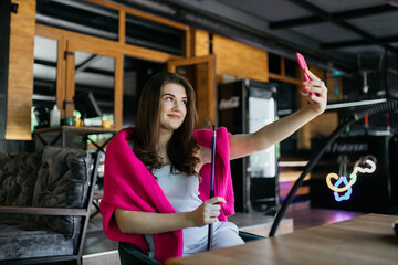 The girl is photographed in a cafe and smokes a hookah. Girl in a cafe smokes a hookah. The girl is sitting in a cafe.