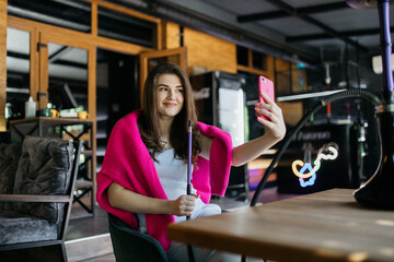 The girl is photographed in a cafe and smokes a hookah. Girl in a cafe smokes a hookah. The girl is sitting in a cafe.