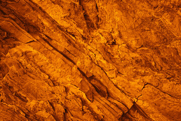 Orange red brown rock texture with cracks. Rough mountain surface. Close-up. Stone background for design. Crushed, broken, crumbled.