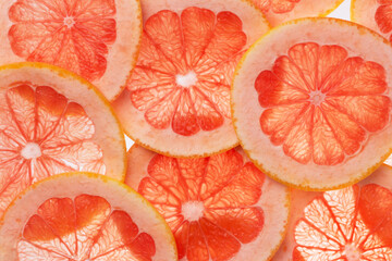 Many grapefruit round slices top view. Grapefruit citrus fruits background.