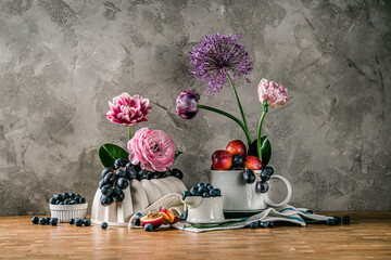 Flowers and fruits on grey background tulip ranunculus 