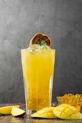 Mango lemonade with bubble tea on dark wooden background