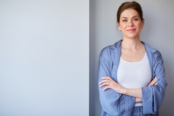 Smiling woman in pajamas standing near gray wall. isolated female portrait.