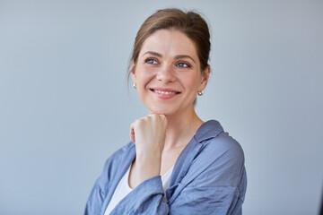 Smiling woman touching chin and looking away.