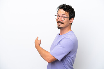 Young man with moustache isolated on white background pointing back