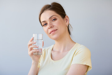 Smiling woman drinking water with glass, isolated head shot.