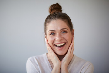 Smiling happy woman with bunch haircut touching face. Female head shot with shallow depth of field.