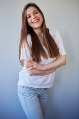 Fototapeta premium Smiling woman in white shirt portrait with crossed arms. Happy girl in white casual clothes.